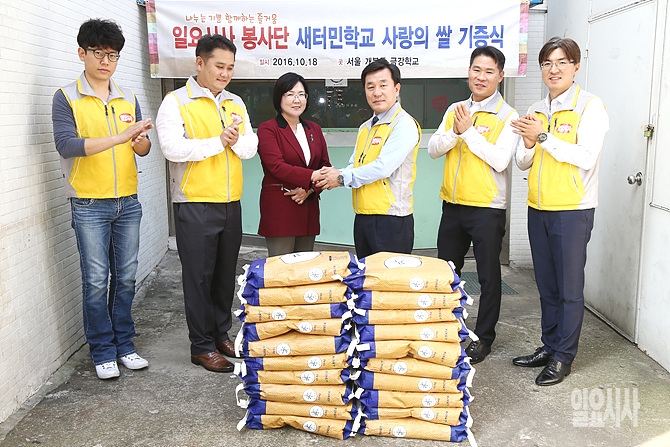 18일, <일요시사> 최민이 편집인 겸 편집국장이 주명화 금강학교 교장과 '사랑의 쌀 기증식' 직후 악수를 나누고 있다.