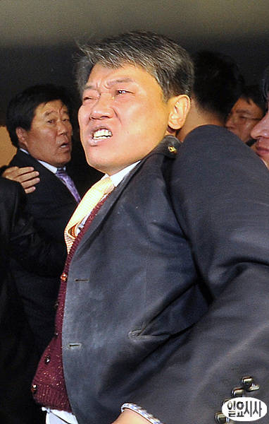 2011년 11월22일, 국회 본회의장 안에서 최루탄 투척 직후 국회 사무처 직원들의 제지를 받자 얼굴을 찡그리고 있는 통합진보당 김선동 의원